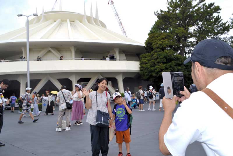 スペース・マウンテンの前で写真撮影する親子＝３１日、浦安市の東京ディズニーランド
