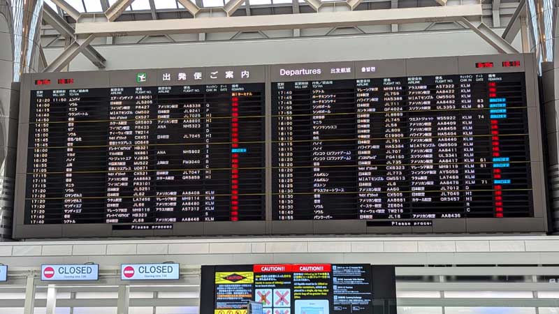 １６日午後１時時点で出発・到着の計２８０便以上が欠航となった成田空港国際線出発ロビーの電光掲示板＝１６日午後、成田市