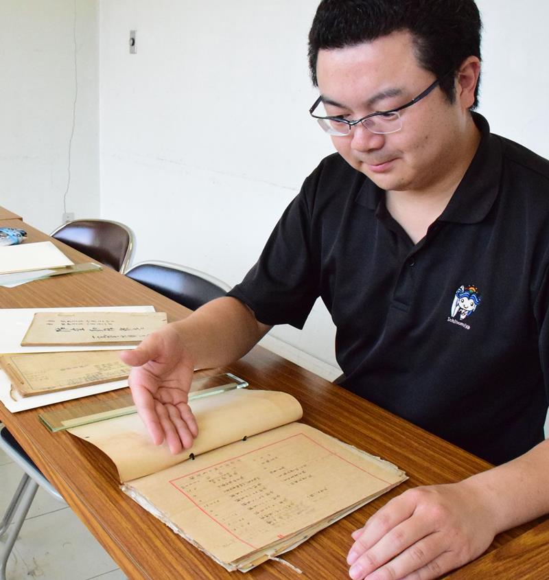 寄贈された郷土の戦争関係の文書を説明する江沢学芸員=一宮町
