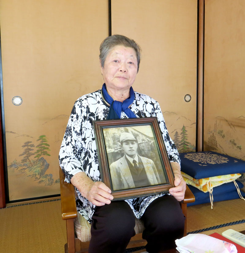 父親の新五郎さんの写真を抱える田辺さん=13日、白子町