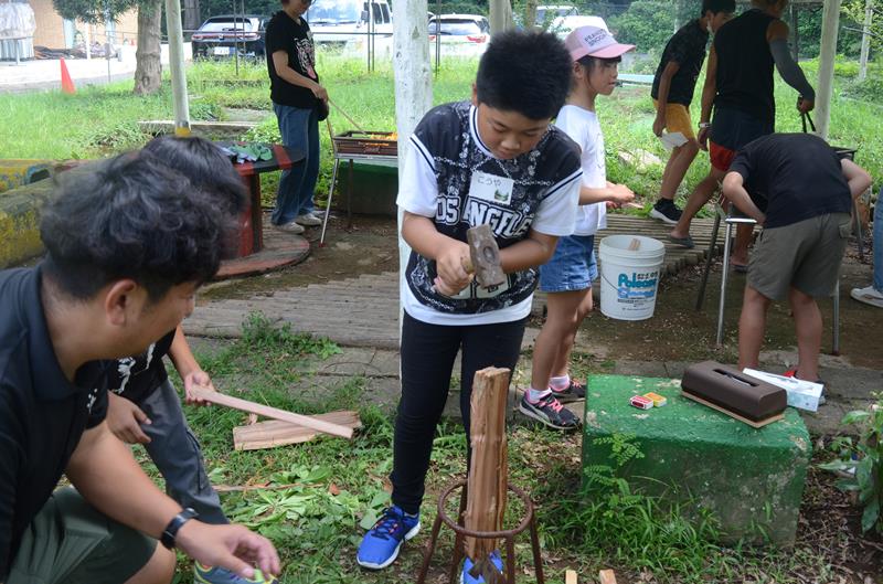 キャンプ場のスタッフにまきの割り方を教わりながら実践する児童＝横芝光町
