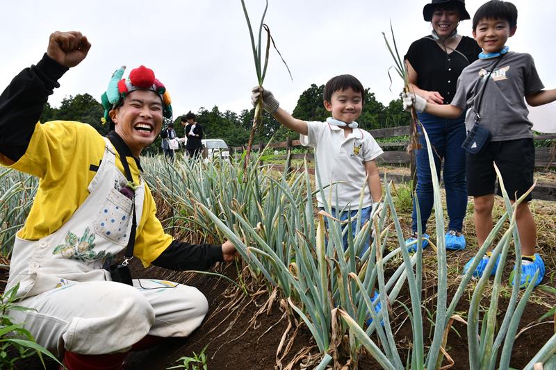 野菜の日の8月31日、ヤサイちゃんと一緒にネギを収穫した参加者=香取市
