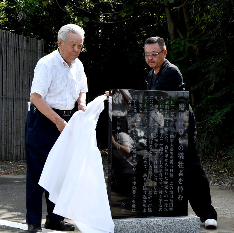碑文石碑を除幕する市川代表（左）と遺族関係者代表の中嶋さん＝６日、野田市
