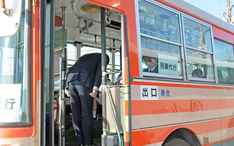 代行バス車内で乗客に頭を下げる、いすみ鉄道の古竹社長=7日朝、いすみ市