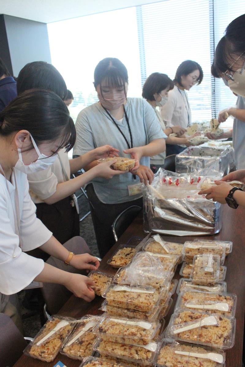 出来上がったご飯をパック詰めする職員＝旭市役所