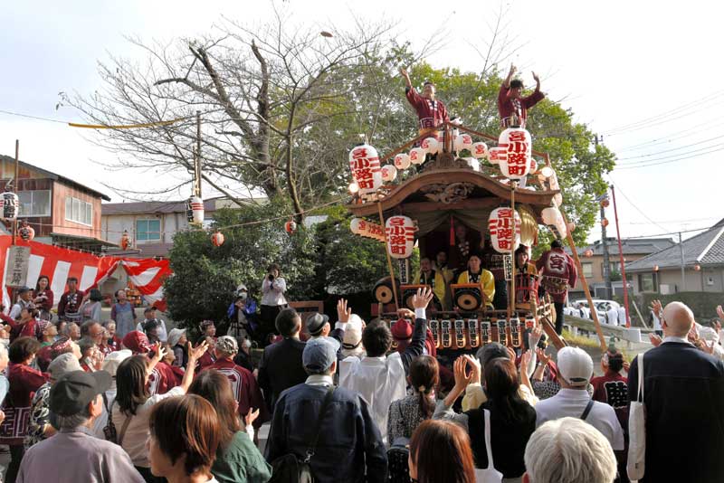 麻賀多神社前で大神輿を出迎えた後、御神酒所から縁起物の餅を投げる宮小路町第一町内会＝１１日、佐倉市