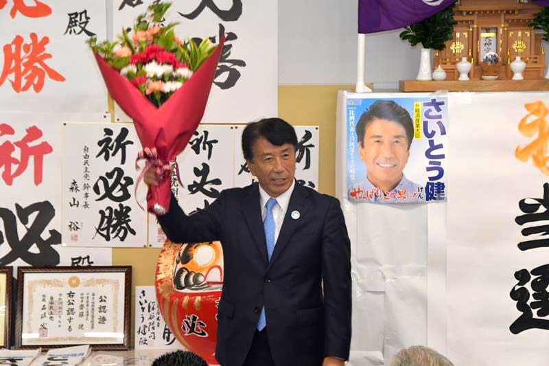 党への逆風下でも６度目の当選を決め、花束を贈られた自民党の斎藤氏＝２７日、流山市
