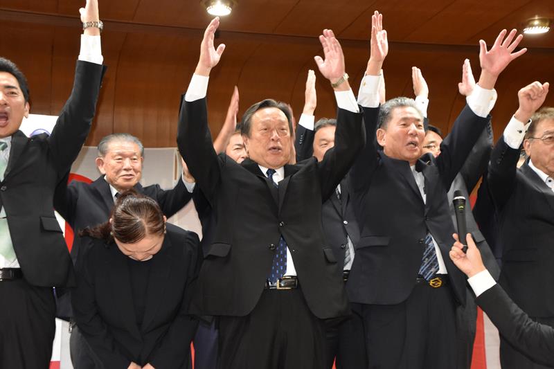 圧勝で１１選を果たし、支援者らと万歳三唱する浜田氏（中央）＝２７日、木更津市