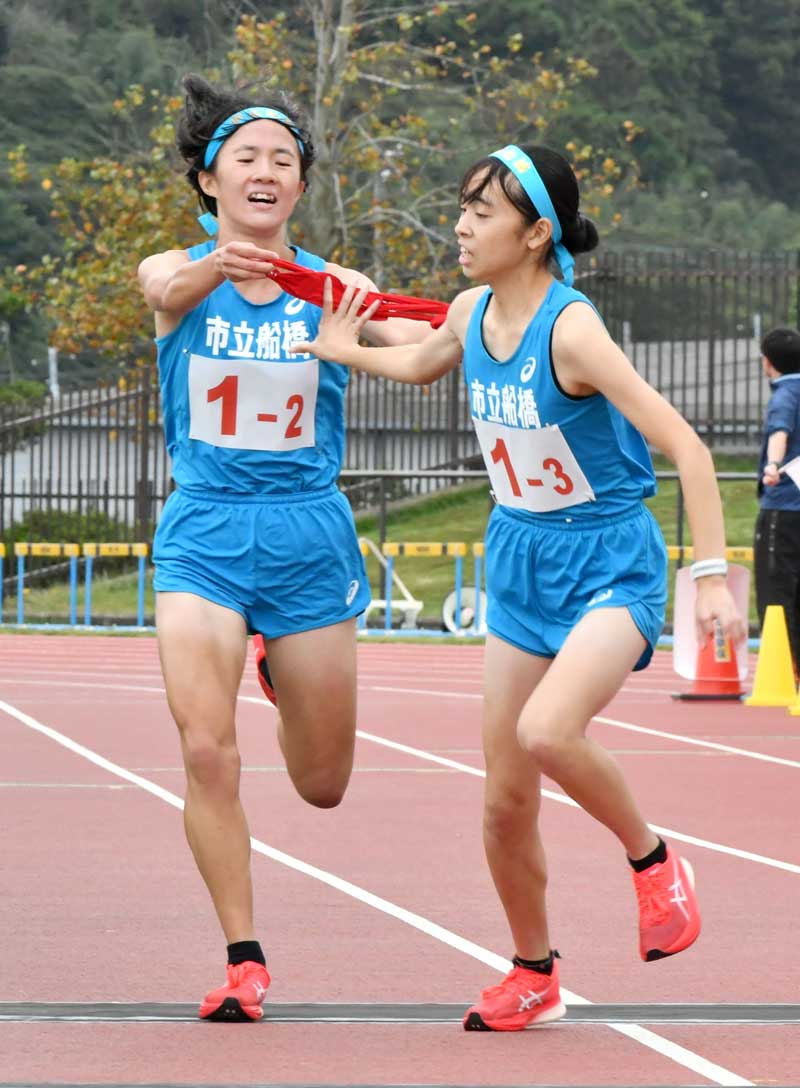 市船橋の2区・横山桃花(左)がトップで3区・藤重桃子へたすきをつなぐ=東総運動場