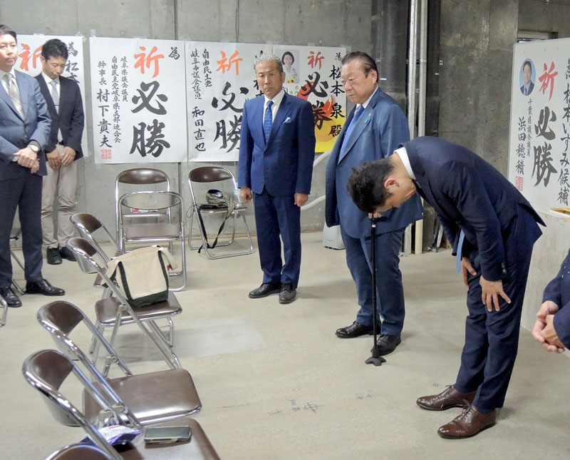 比例復活も逃し選挙事務所で支持者らに頭を下げる自民党の松本氏。隣は選対本部長の桜田氏＝２８日、柏市