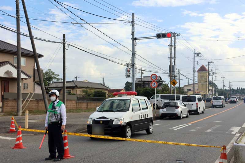 強盗殺人事件現場のホテル(右奥)沿いの道路は規制線が張られた＝１日午後、市原市中高根（画像一部加工）