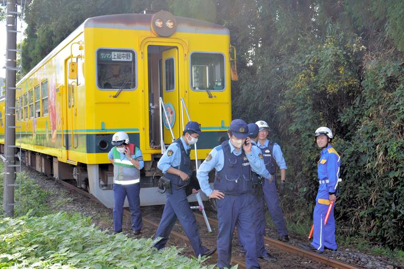 脱線したいすみ鉄道の車両周辺で事故の対応に当たる警察官ら＝１０月、いすみ市