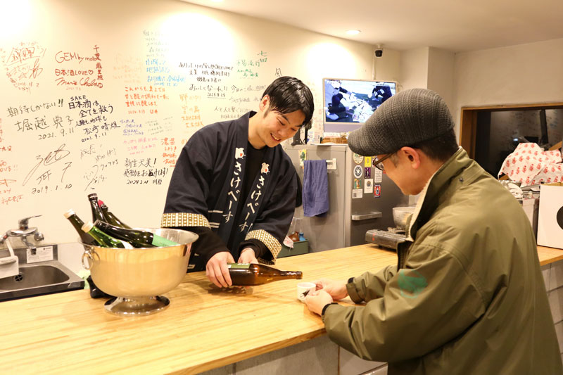 客に日本酒を提供する宍戸さん=千葉市稲毛区