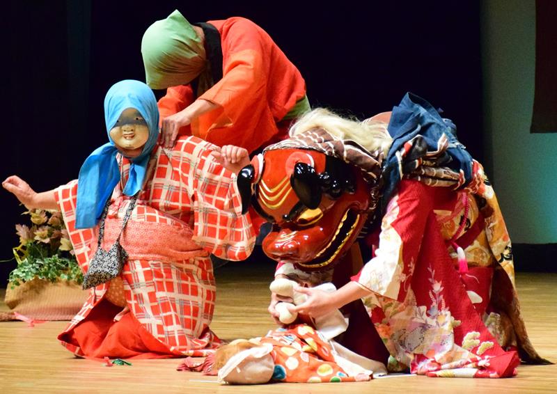 永田旭連の獅子舞。獅子が子どものおしめを替えている=19日、長生村文化会館