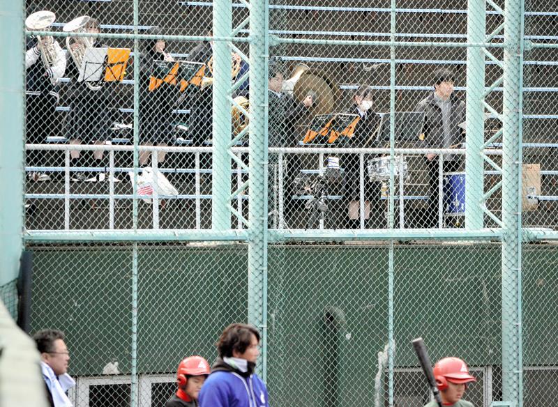 バックネット裏で応援曲を演奏する松尾高の吹奏楽部員ら＝東金市