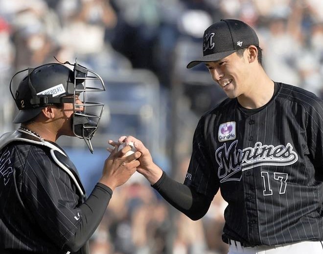 プロ野球史上１６人目となる完全試合を達成し、捕手の松川（左）からボールを受け取る佐々木朗希＝２０２２年４月、ＺＯＺＯマリン（共同）