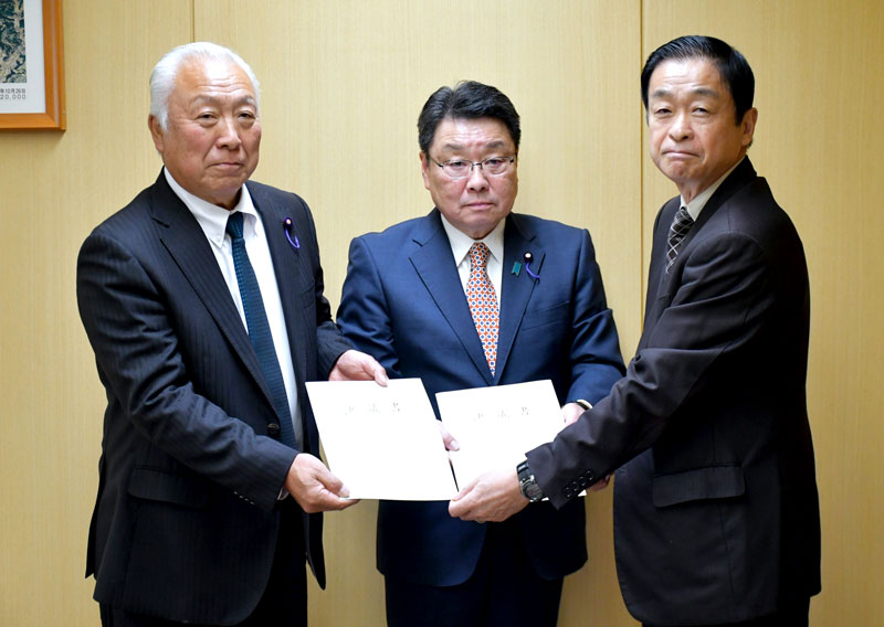 成田空港と芝山・多古の両町発展に向けた要望をまとめた決議書をＮＡＡの平山共生・用地部門長（右）に手渡す（左から）鵜沢議長と伊橋議長＝成田市
