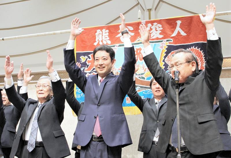 再選が確実となり、支持者らと万歳三唱する熊谷氏(中央)=16日、千葉市中央区