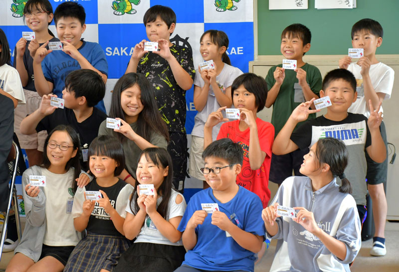 「子供自転車免許証」を受け取り喜ぶ竜角寺台小学校の児童=27日、栄町