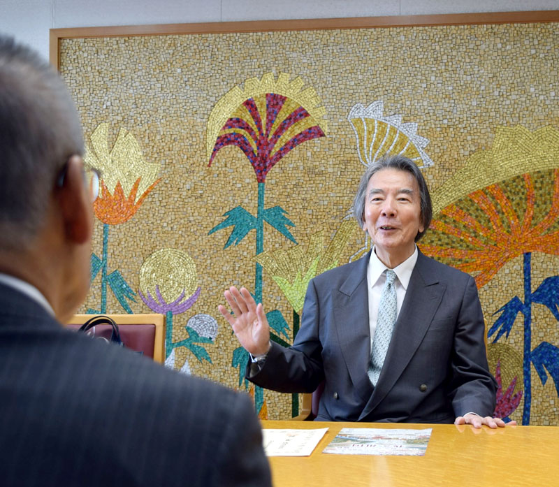 松戸市長（手前）に自らの音楽活動について語る武藤さん＝船橋市役所