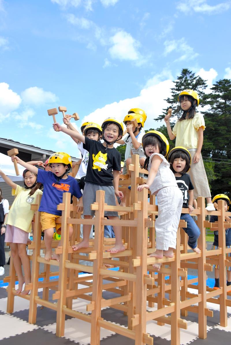 協力して作り上げたジャングルジムにうれしそうに上る子どもたち