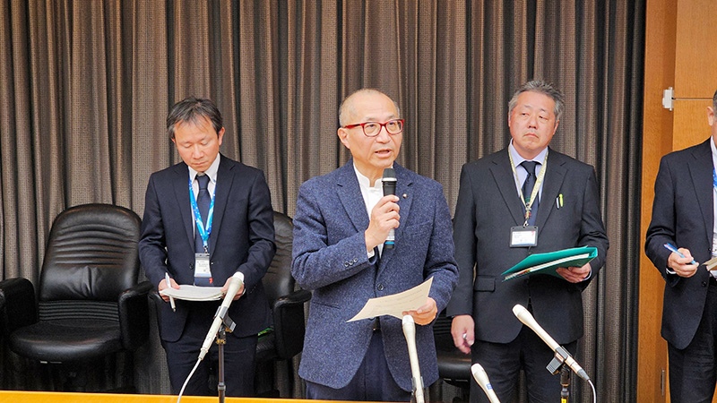 記者団の取材に応じる座長の釜井俊孝・京大名誉教授（中央）＝１８日、県庁