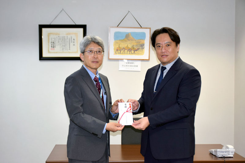 星山理事長（右）から支援金を受け取る県教育庁文化財課の大内課長