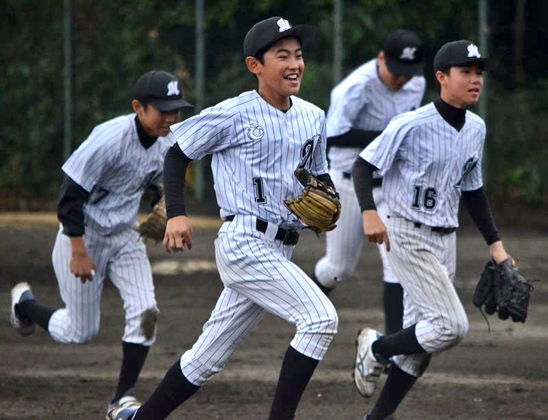 西武ジュニアとの練習試合で仲間とともに笑顔を見せる千葉ロッテマリーンズジュニアの糟谷主将（中央）＝２１日、稲毛海浜公園