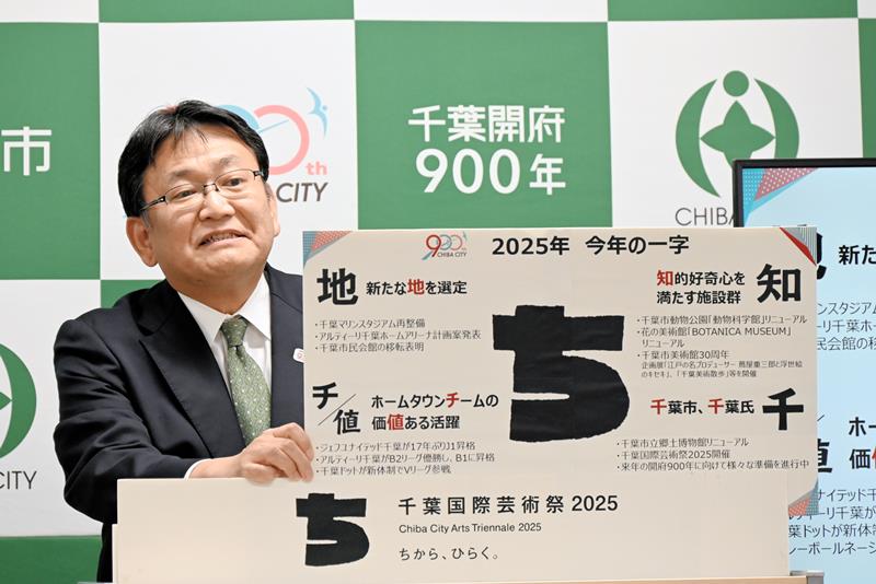 今年を表す一字として「ち」を掲げ、千葉市のこの１年について説明する神谷市長＝２５日、千葉市役所