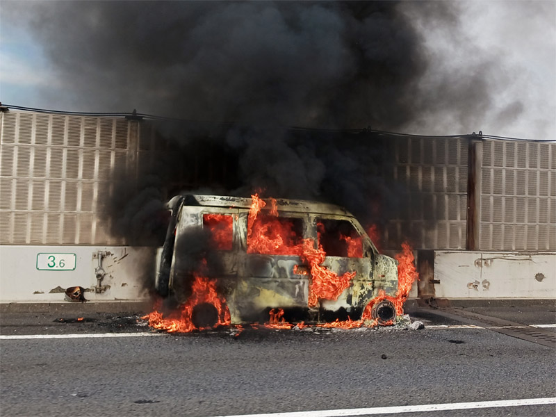 東関道下りの車線脇で炎上する車=15日午後1時55分ごろ、船橋市