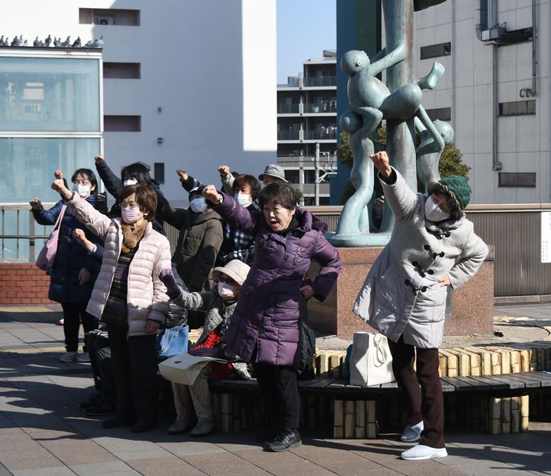 第一声の会場で拳を掲げて意気込む支持者ら＝２７日、津田沼駅前