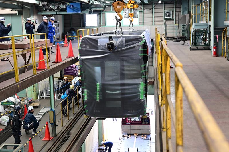 クレーンで持ち上げられる「０形」の新車両＝６日、千葉市稲毛区の千葉都市モノレール車両基地