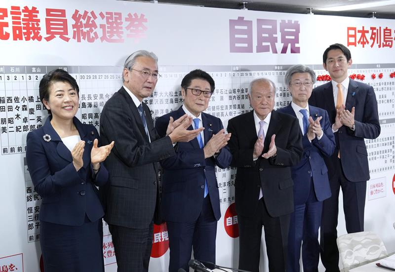 当確者の名前にバラを付け、拍手する自民党の（左から）有村総務会長、古屋選対委員長、松山参院議員会長、鈴木幹事長、石井参院幹事長、小林政調会長＝８日午後８時３５分、東京・永田町の党本部（共同）